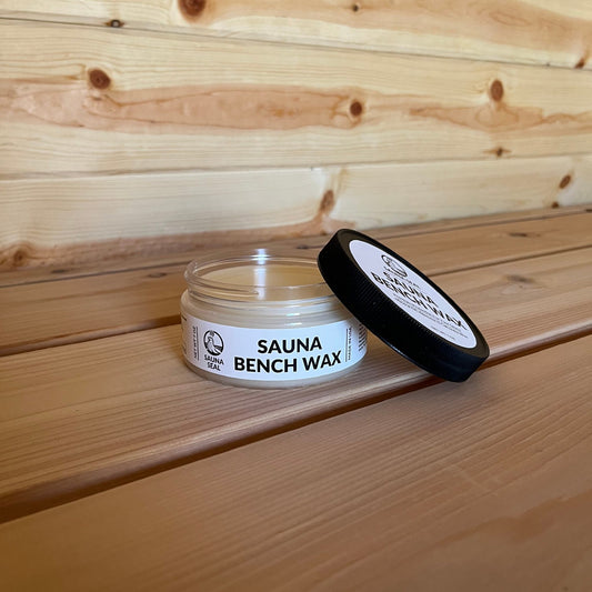 Sauna Seal Sauna Bench Wax jar with white label and black lid on a wooden sauna bench
