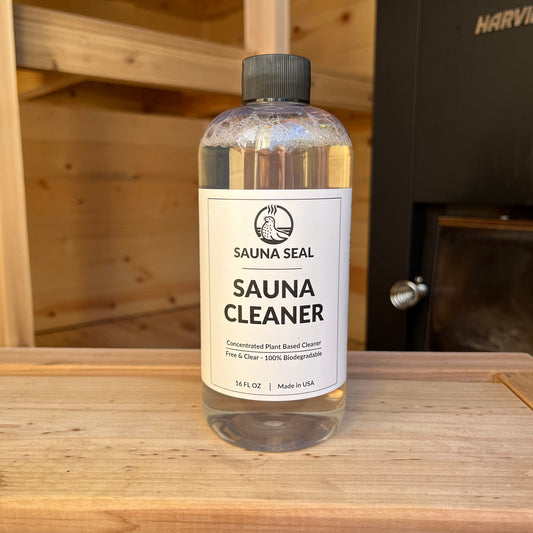 clear bottle with white label and sauna stove and bench in background