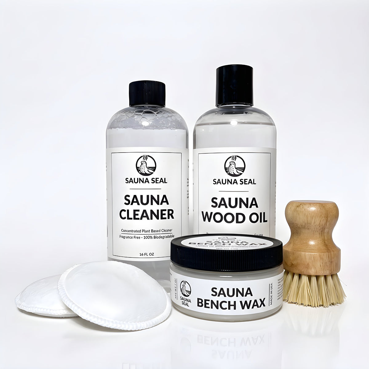 Sauna Seal Complete Sauna Care Kit: Sauna Cleaner 16oz, Sauna Wood Oil 16oz, Sauna Bench Wax 7oz, two applicator pads and bench scrub brush on a white background